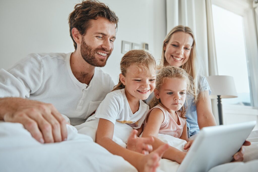 Family, bed and tablet with children and parents streaming an online subscription in the bed at hom